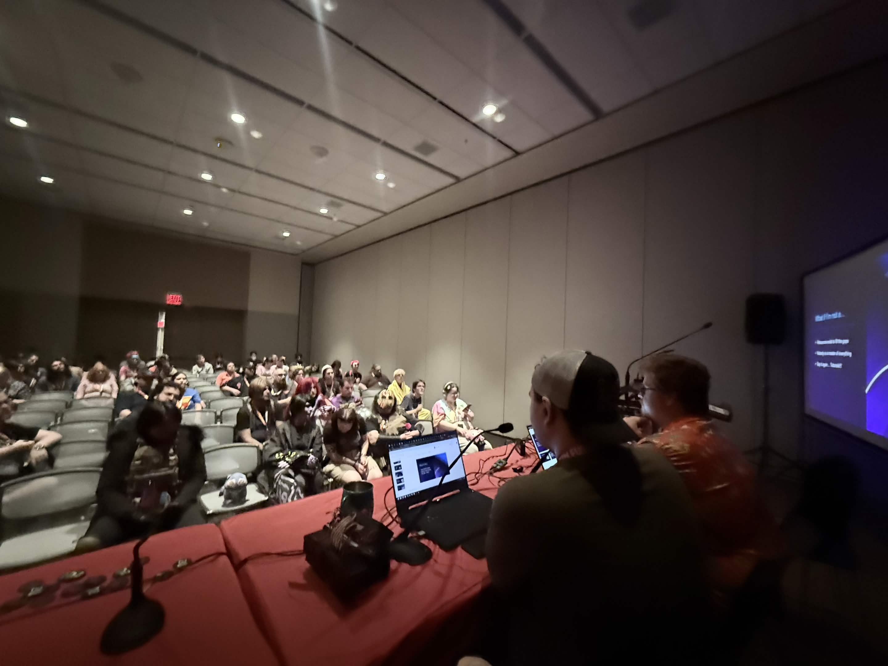 The Primordial Games team presenting a panel to a convention audience